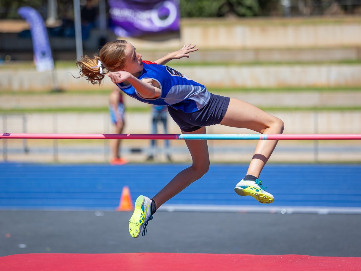 Young athlete clearing the high jump bar